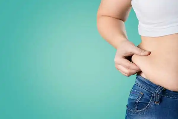 Image of woman pinching her love handles to show weight gain Faringdon
